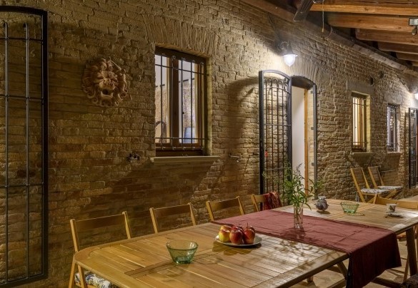 Porch with set dining table at night – Ca Lucciola