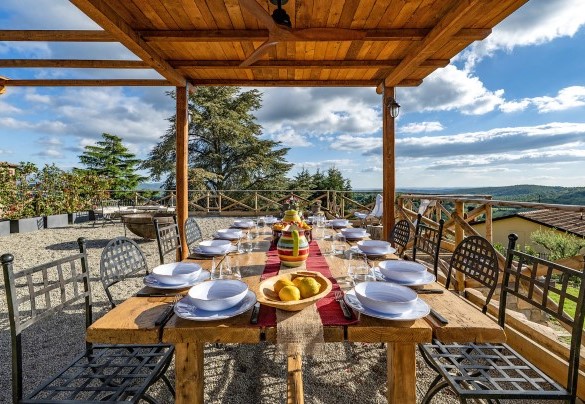 Il tavolo da pranzo all’aperto, accanto alla cucina esterna, ombreggiato dalla pergola - I Tramonti