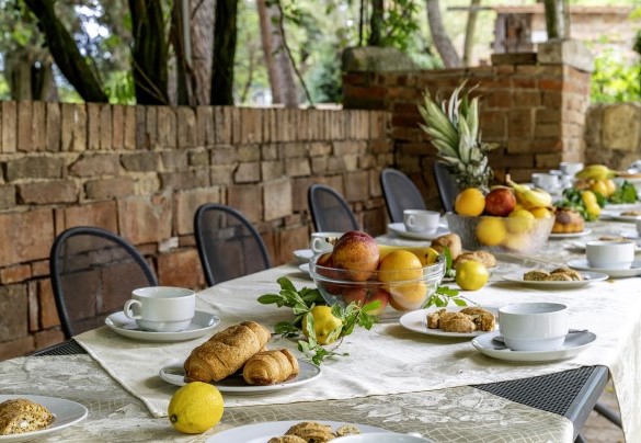 Outdoor dining table shaded by a pergola - La Burraia