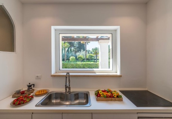 The kitchen overlooking the garden with an induction hob - Villa Corte Sant’Anna