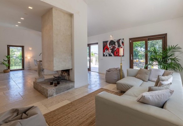 The open-plan living room with living area, dining area and ornamental fireplace - Villa Corte Sant’Anna