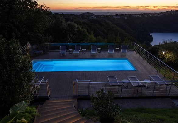 La piscina sospesa su un decking panoramico, avvolta dalle calde luci del tramonto – Villa Giulia