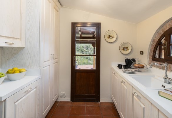 The service kitchen, where a washing machine is available. The service kitchen has access to a terracotta-tiled terrace – Villa Loredana